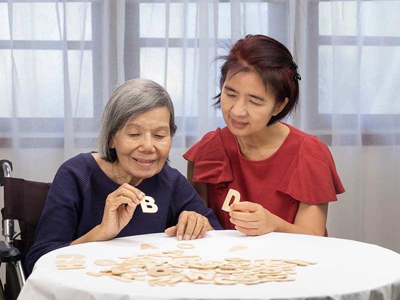 Elderly woman playing memory game with daughter