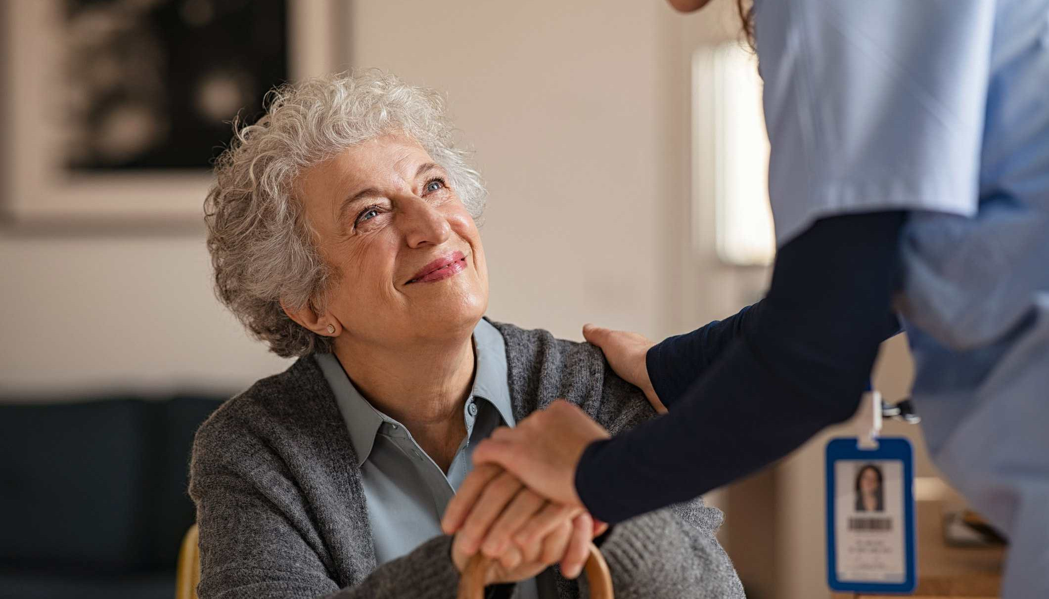 Nurse greets seated resident