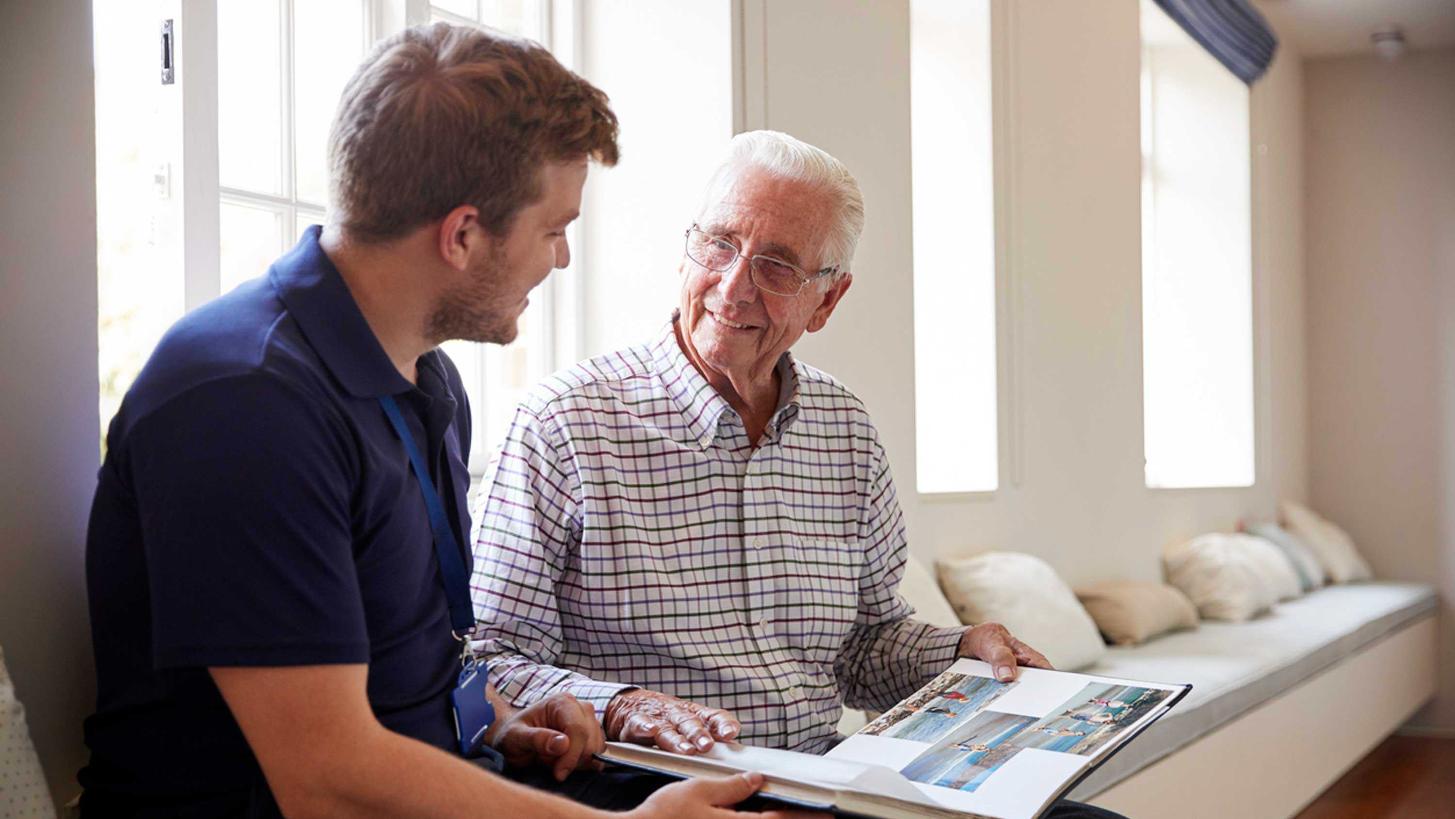 Resident shows photo album to staff member