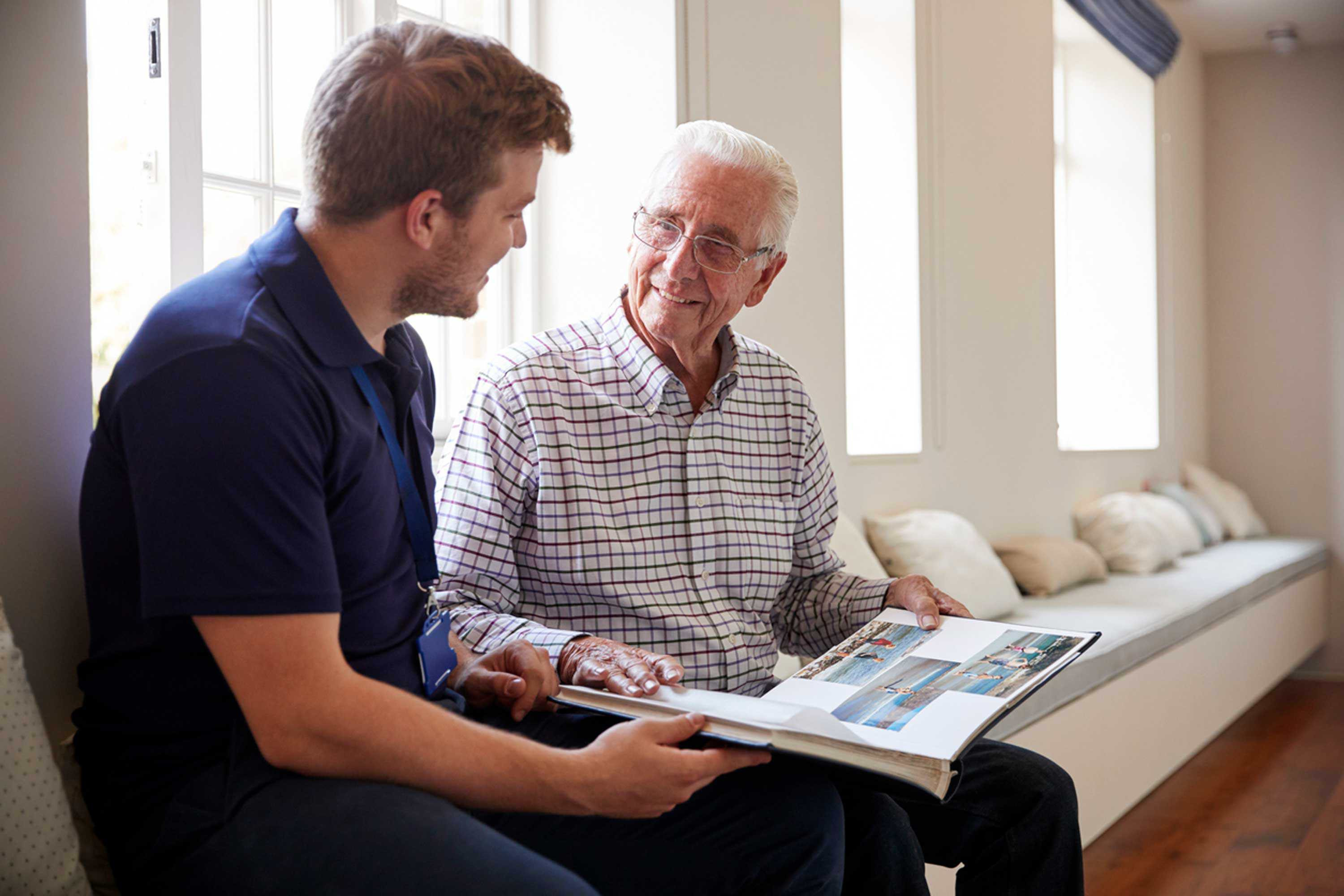 Resident shows photo album to staff member