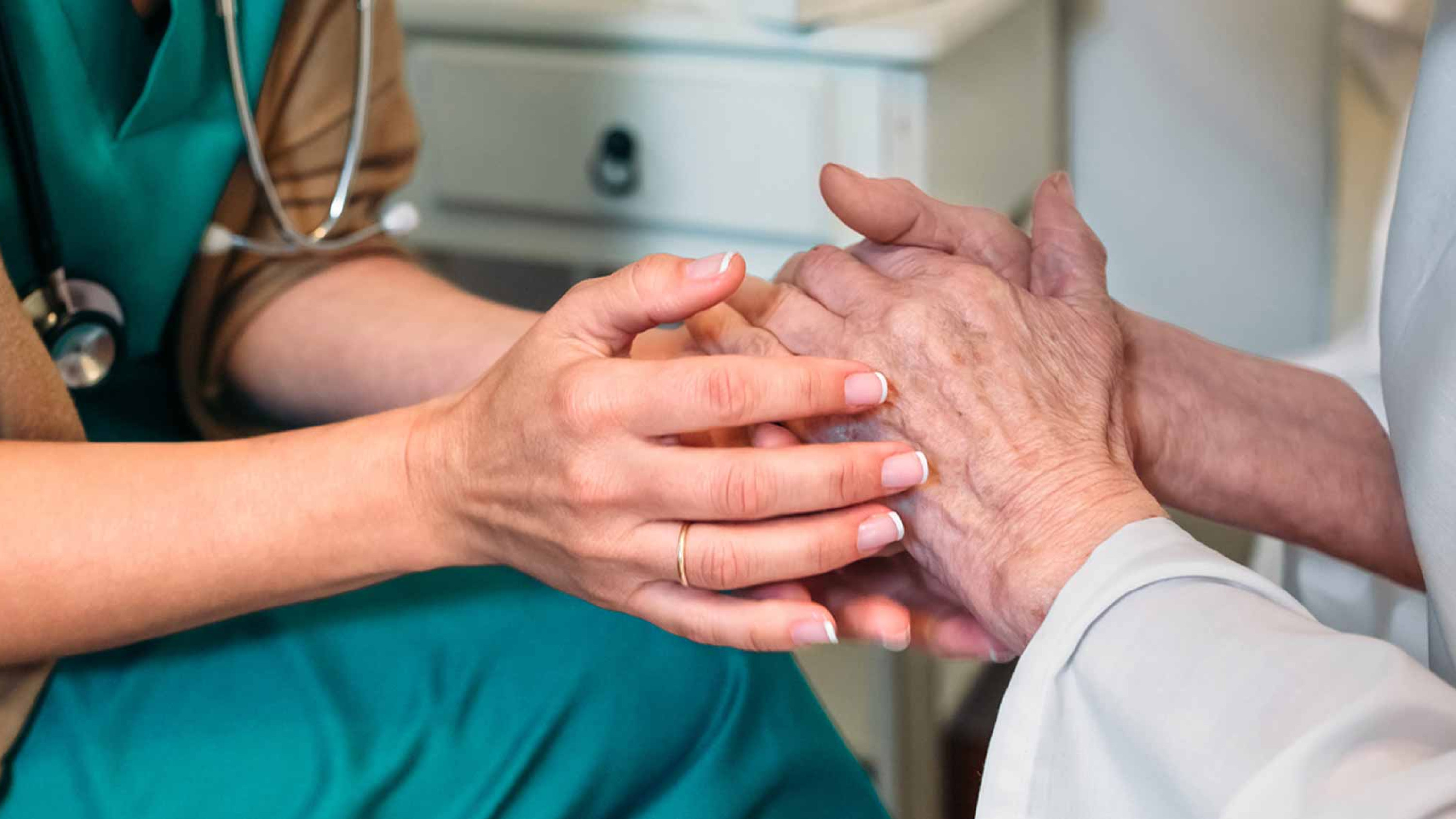 Caregiver holding resident's hands