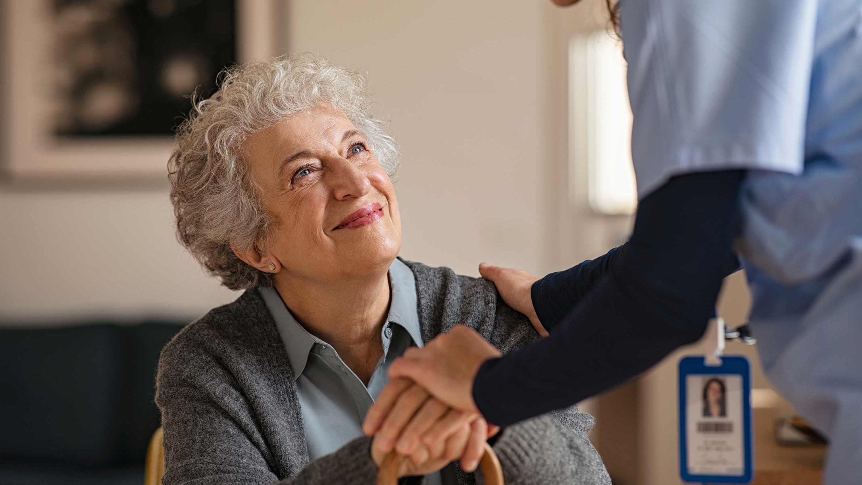 CRISTA Senior Living - Nurse greets seated resident