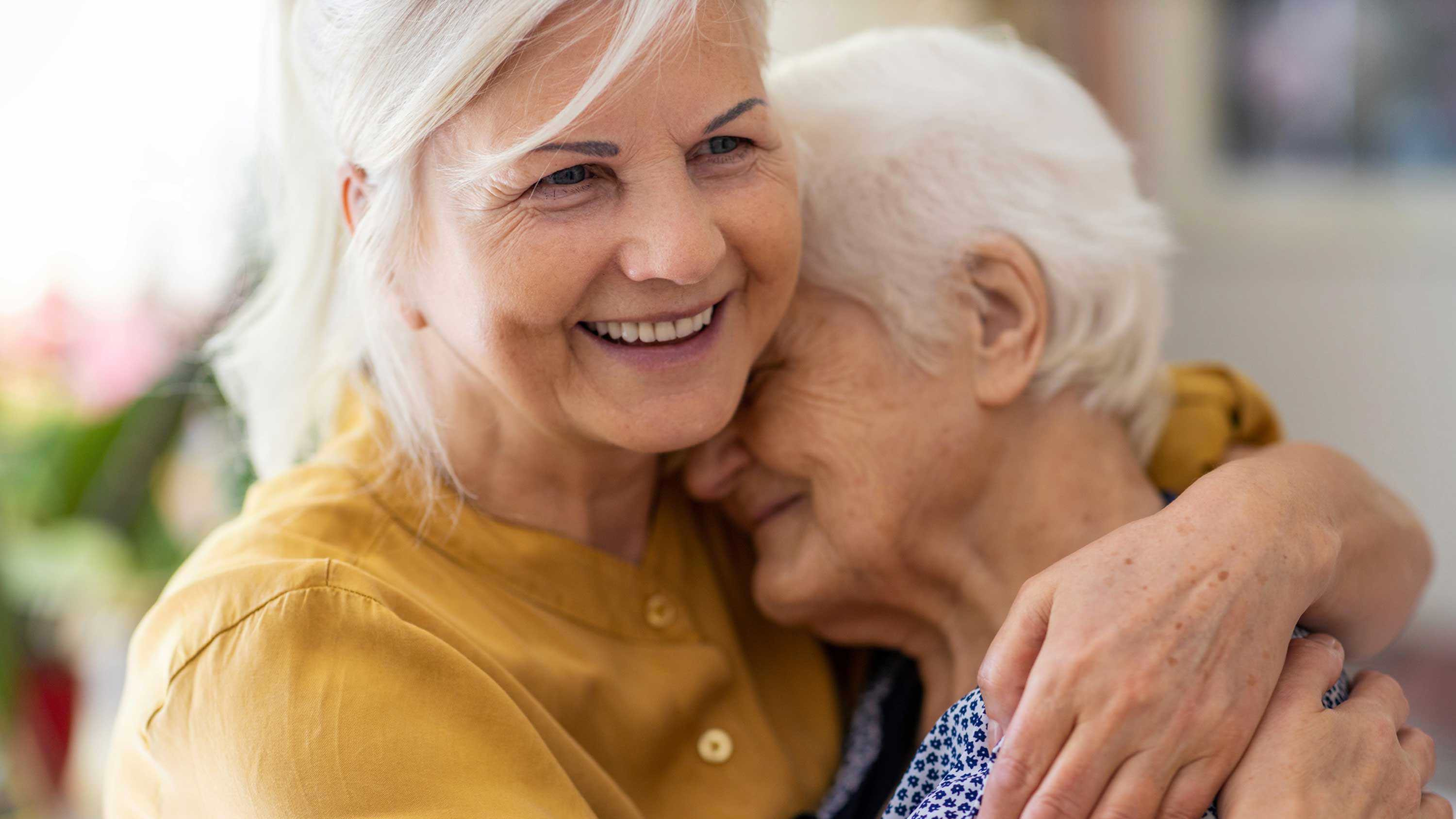 CRISTA Senior Living - Caregiver hugs elderly woman